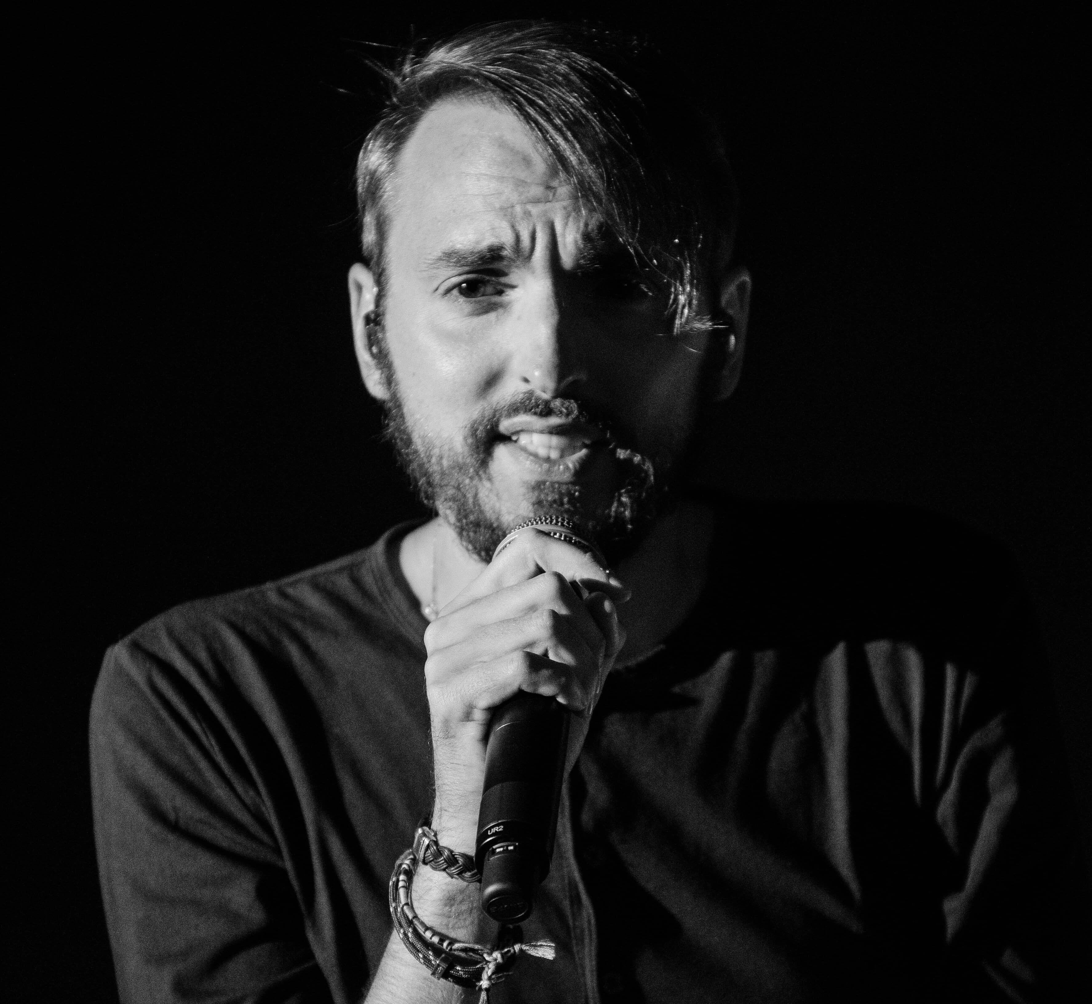 a bearded man posing with his hand on his chin